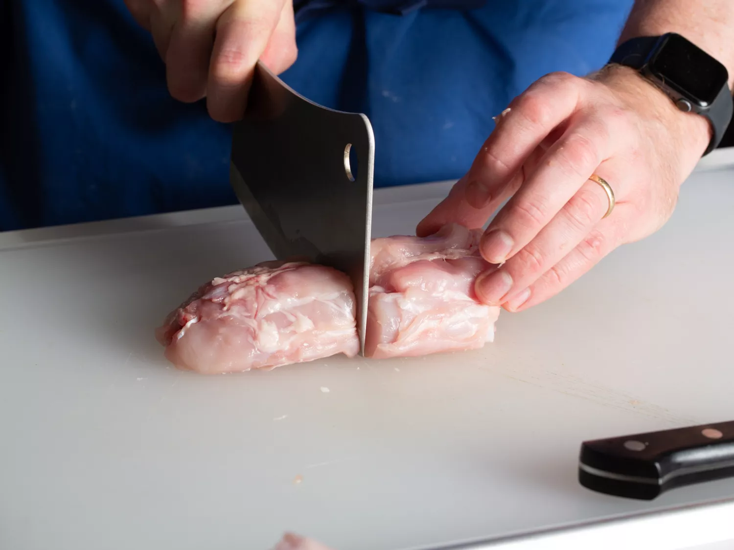 Cutting rabbit saddle in half with cleaver.