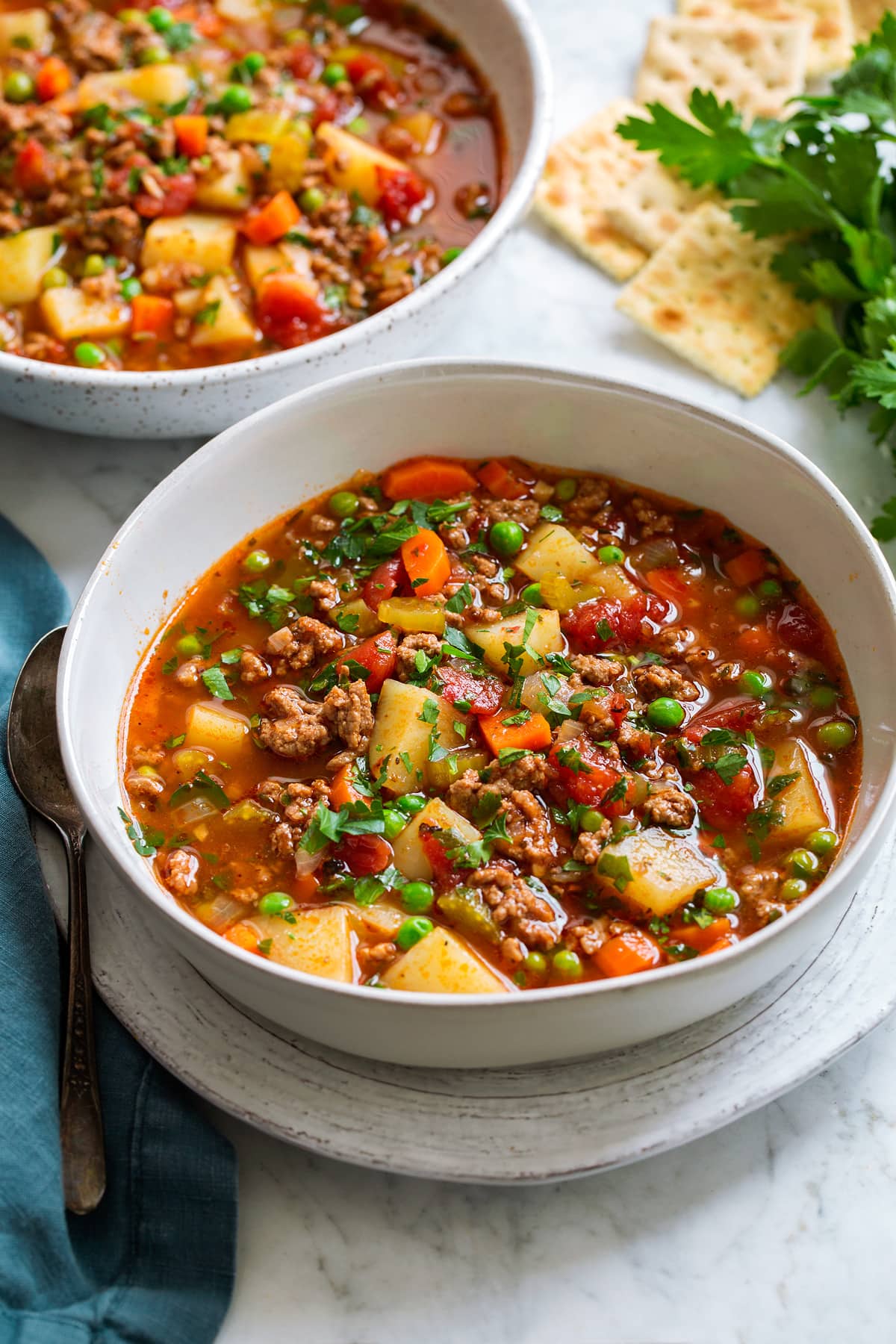 two servings of hamburger soup in white serving bowls